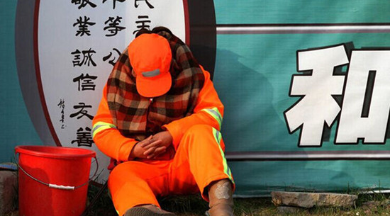 每天必須12小時(shí)在路面值守以時(shí)刻保持路面的清潔，環(huán)衛(wèi)工人只能蜷縮在馬路啃饅頭、打瞌睡